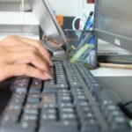 les mains d'une femme tapent sur un clavier d'ordinateur