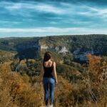 une jeune femme admirant un paysage vallonné